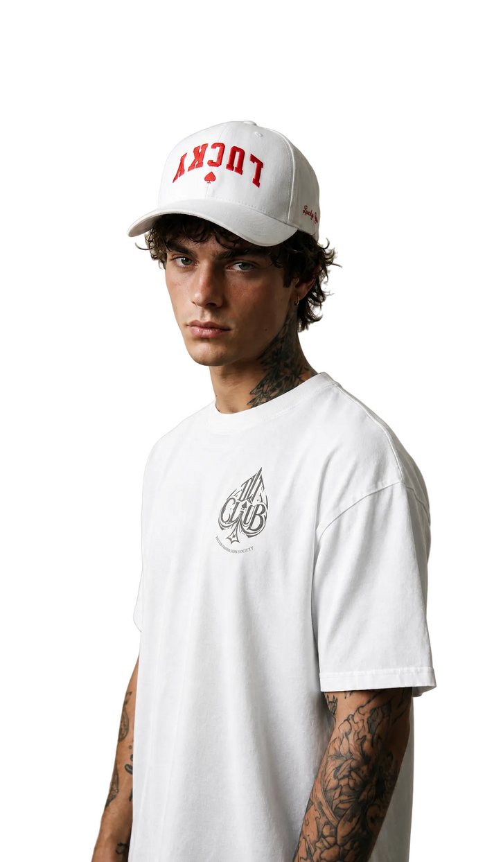 Model in a white cap with red embroidery and a white shirt, Tilted Spades