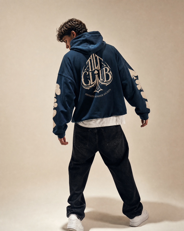 Model wearing the Spyre Hoodie, white studio, Tilted Spades